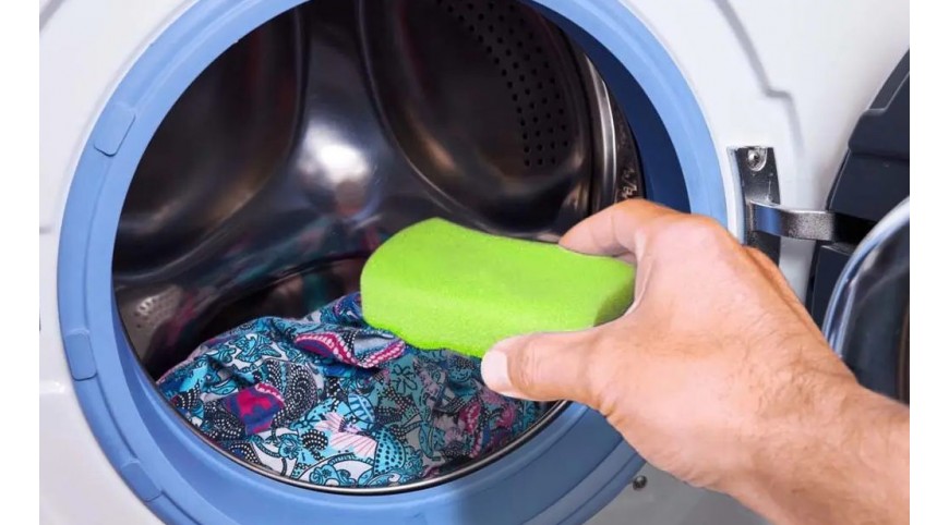 un enfant occupé fait la lessive, vide la machine à laver, nettoie